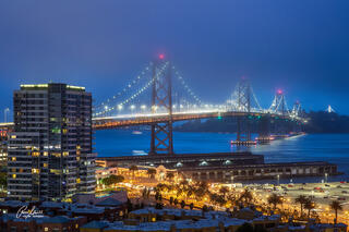 A twilight image of the Bay Bridge from San Francisco from a high rise building.
