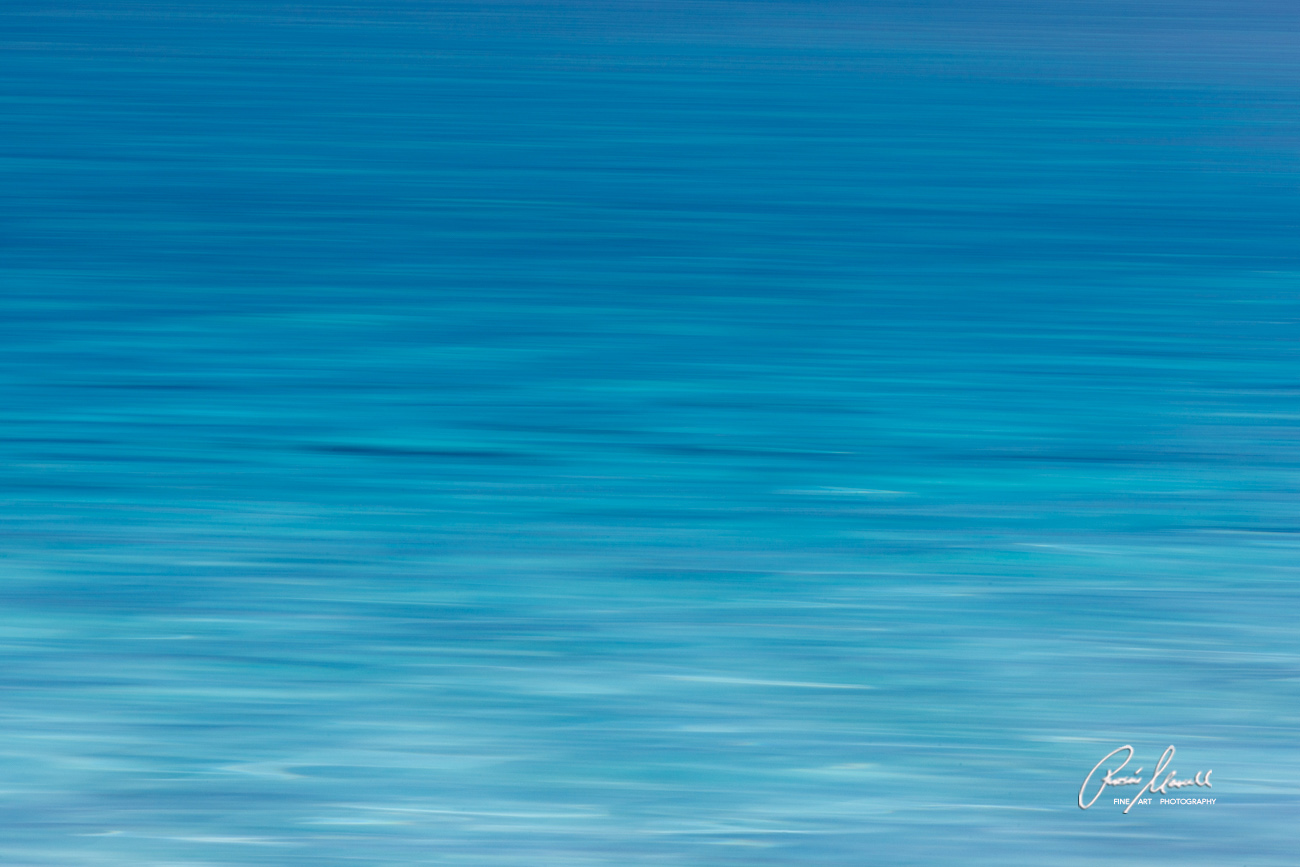 Different hues of turquoise blue water as the beautiful Tahitian waves are captured in a long exposure.